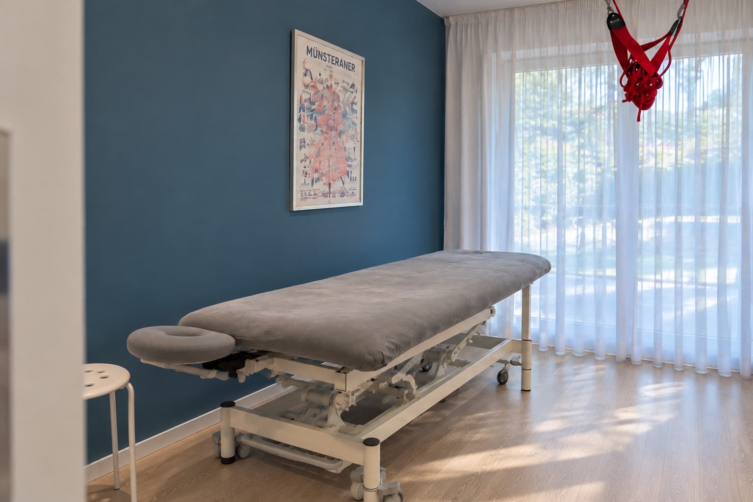 Höhenverstellbare Therapieliege vor der blauen Wand